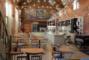 a restaurant with wooden tables and chairs and a bar at The Chapel House Cheshire in Pickmere