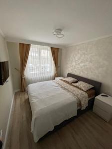 a bedroom with a large bed and a window at Apartament 1 Lalelelor in Năsăud