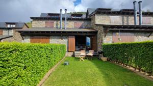 une maison avec une pelouse devant un bâtiment dans l'établissement Encantadora Casa adosada en Alp, à Alp