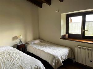 a bedroom with two beds and a window at Encantadora Casa adosada en Alp in Alp