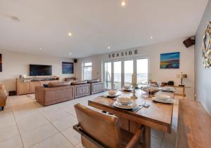 a dining room and living room with a table and chairs at Beadnell Beach House in Beadnell