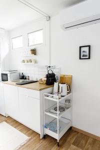 a kitchen with white cabinets and a counter top at Nordin Apartman in Hódmezővásárhely