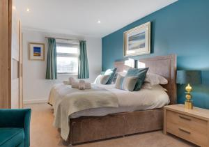 a bedroom with a large bed with blue walls at Beadnell Beach House in Beadnell