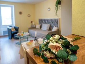 a living room with a bed and a table with flowers at Studio Studio des Halles by Interhome in Pornic
