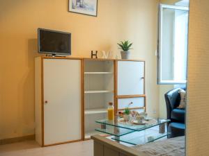 a living room with a tv on top of a cabinet at Studio Studio des Halles by Interhome in Pornic