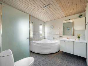 y baño con bañera, aseo y lavamanos. en Holiday Home Emelin - 475m from the sea in Western Jutland by Interhome, en Ringkøbing