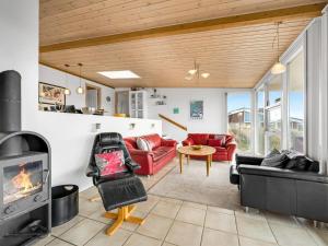 sala de estar con muebles de color rojo y chimenea en Holiday Home Emelin - 475m from the sea in Western Jutland by Interhome, en Ringkøbing