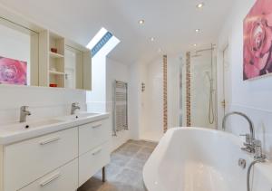 a bathroom with a tub and two sinks and a shower at Moo House in Beadnell +62 photos