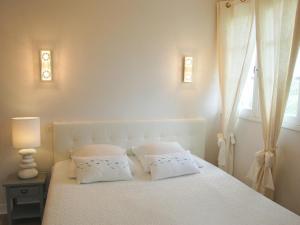 ein Schlafzimmer mit einem weißen Bett mit zwei Kissen in der Unterkunft Holiday Home La Malouinière des Longchamps by Interhome in Saint-Jouan-des-Guérets