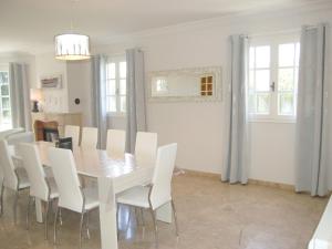 ein Esszimmer mit einem weißen Tisch und weißen Stühlen in der Unterkunft Holiday Home La Malouinière des Longchamps by Interhome in Saint-Jouan-des-Guérets