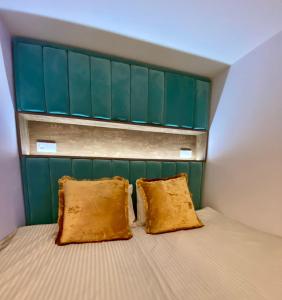 um quarto com uma cabeceira verde e 2 almofadas numa cama em Luxury Queen V apartment with Jacuzzi em Kaunas