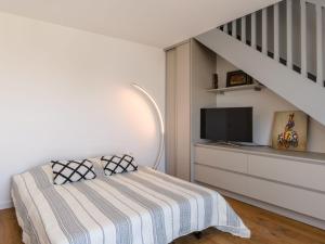 a bedroom with a bed with a television and a staircase at Apartment Claire-4 by Interhome in Arcachon