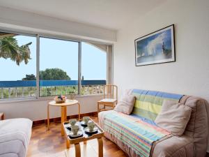 un salon avec un canapé et deux fenêtres dans l'établissement Apartment Mykonos-3 by Interhome, à Port-Leucate