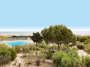 Elle offre une vue sur un jardin avec une piscine et des arbres. dans l'établissement Apartment Mykonos-3 by Interhome, à Port-Leucate