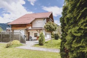a cottage with a red roof and a fence at Chalet Molly by we rent in Zell am See