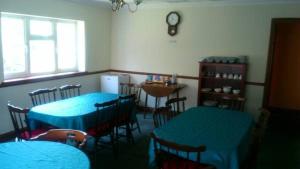 a room with blue tables and chairs in a restaurant at The Lodge Guest House in Grain