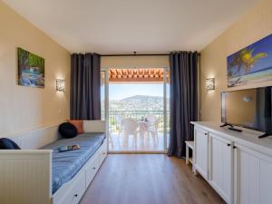 a bedroom with a bed and a view of a balcony at Apartment Le Hameau des Issambres-6 by Interhome in Les Issambres