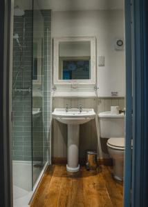 a bathroom with a sink and a toilet and a shower at The Swan at Tarporley in Tarporley