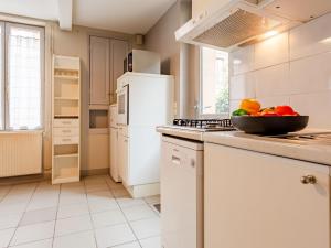 - une cuisine blanche avec un bol de fruits sur le comptoir dans l'établissement Holiday Home L'Aguesseau by Interhome, à Trouville-sur-Mer