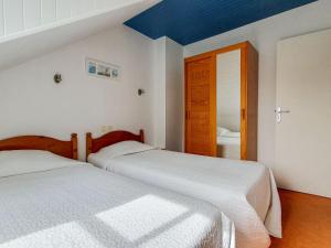 two beds in a bedroom with a blue ceiling at Apartment Le Renard by Interhome in Saint-Jouan-des-Guérets +8 photos
