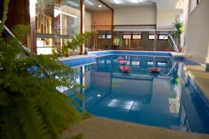 una gran piscina con plantas y suelos de baldosas azules en Agua Viva Eco H Wellness Castro Urdiales, en Castro Urdiales