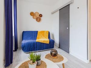 uma sala de estar com um sofá azul e duas mesas em Studio La Batelière by Interhome em Trouville-sur-Mer