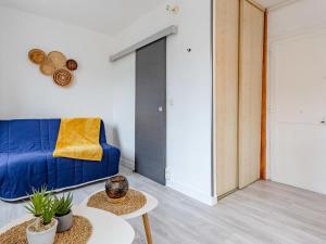 een woonkamer met een blauwe bank en een tafel bij Studio La Batelière by Interhome in Trouville-sur-Mer