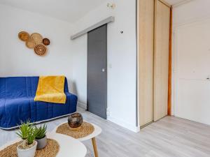 un soggiorno con un divano blu e un tavolo di Studio La Batelière by Interhome a Trouville-sur-Mer