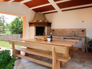 une cuisine avec une table en bois et une cheminée dans l'établissement Apartment Rosa - LBN380 by Interhome, à Krnica