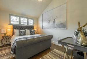 a bedroom with a bed and a table with a desk at The Haybarn in Cranleigh