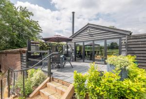 a house with a patio with an umbrella at The Haybarn in Cranleigh
