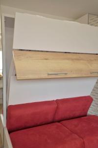 een wit bed met een rode bank in een kamer bij Apartment Charme de Villès Martin by Interhome in Saint-Nazaire