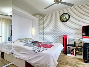een slaapkamer met een bed en een klok aan de muur bij Apartment Charme de Villès Martin by Interhome in Saint-Nazaire +18 foto's