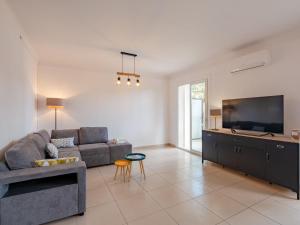 a living room with a couch and a flat screen tv at Apartment Le Cyrnos by Interhome in Saint-Aygulf