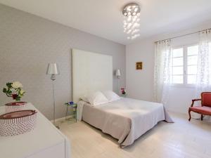 a white bedroom with a bed and a chair at Apartment Villa Manon by Interhome in Mouans-Sartoux