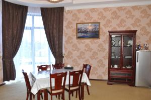 a dining room with a white table and chairs at Firuz Hotel in Khujand