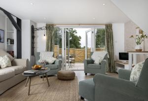 a living room with two chairs and a couch and a table at Winacres Cottage in Nailsworth