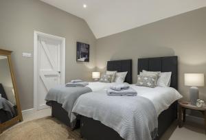 a bedroom with two beds with towels on them at Winacres Cottage in Nailsworth