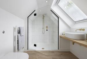 a bathroom with a glass shower and a sink at Winacres Cottage in Nailsworth +11 photos