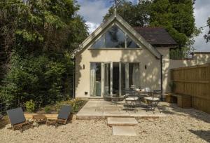 a patio with a table and chairs in front of a house at Winacres Cottage in Nailsworth