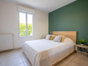 a bedroom with a large white bed with a window at Apartment Royal Rivage-3 by Interhome in Carqueiranne