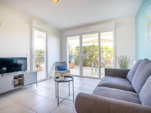 a living room with a couch and a tv at Apartment Royal Rivage-3 by Interhome in Carqueiranne