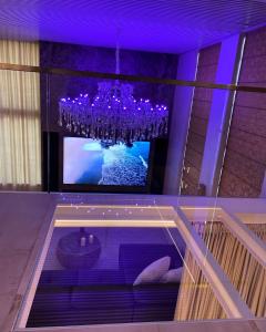 a dining room with a chandelier and a tv at Luxury Queen V apartment with Jacuzzi in Kaunas