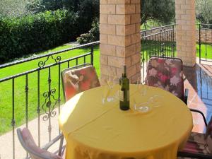 - une table jaune avec une bouteille de vin sur un balcon dans l'établissement Apartment Martina - LBN377 by Interhome, à Krnica