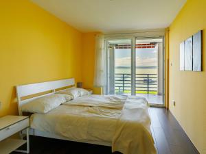 ein Schlafzimmer mit einem Bett und einem großen Fenster in der Unterkunft Apartment Olivia by Interhome in Balatonőszöd