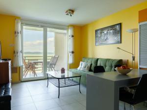 ein Wohnzimmer mit einem grünen Sofa und einem Tisch in der Unterkunft Apartment Olivia by Interhome in Balatonőszöd