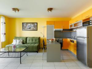 eine Küche und ein Wohnzimmer mit einem Sofa und einem Tisch in der Unterkunft Apartment Olivia by Interhome in Balatonőszöd