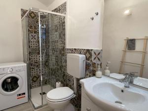 een badkamer met een toilet, een wastafel en een wasmachine bij Apartment La Finestra sulla Piazza by Interhome in Imperia