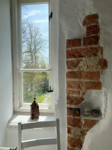 a window in a room with a brick wall at Wasserburg Turow in Glewitz