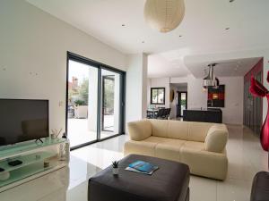 a living room with a couch and a tv at Holiday Home L'Oustaloun by Interhome in Saint-Aygulf